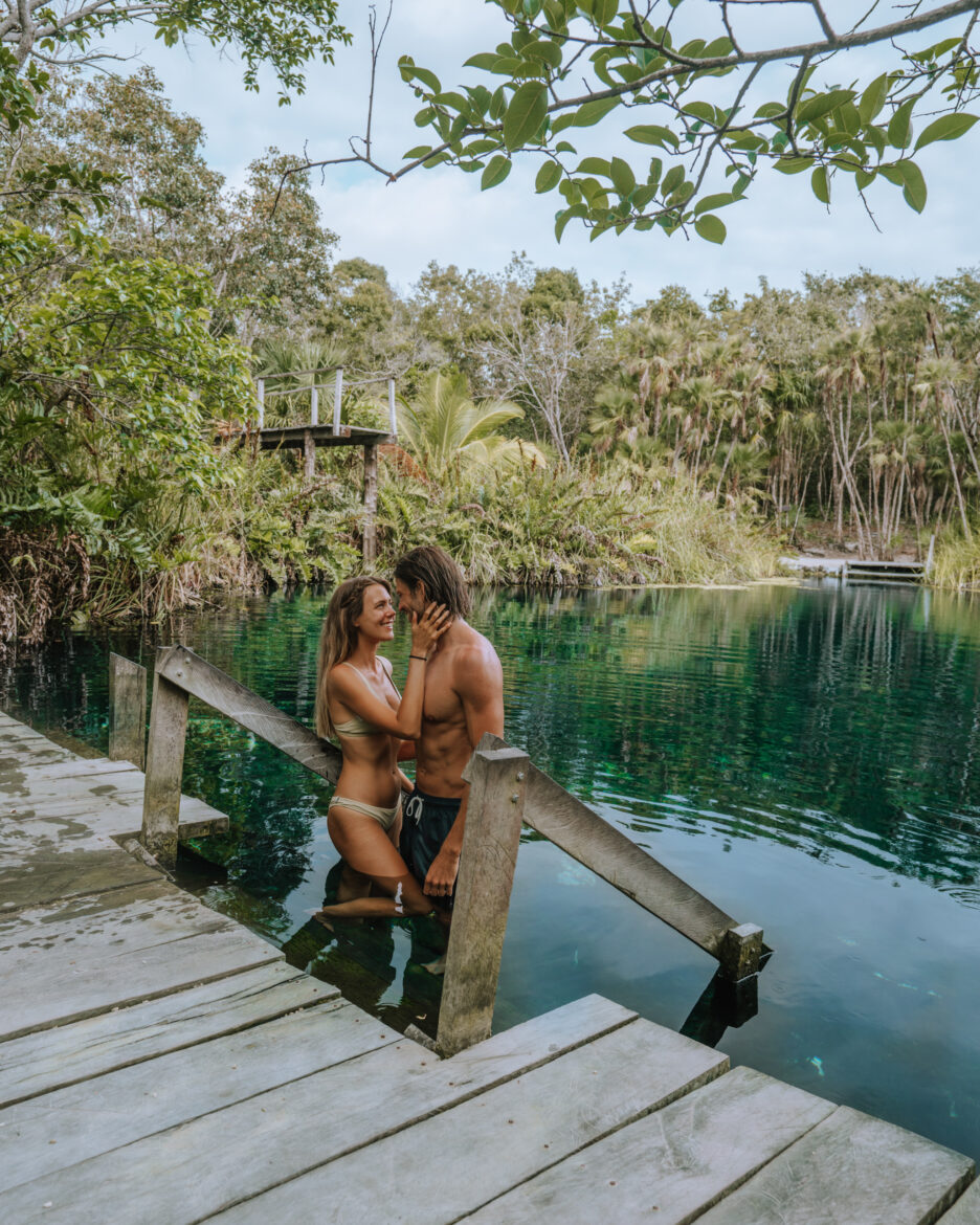 A man and woman standing on a dock in the water.