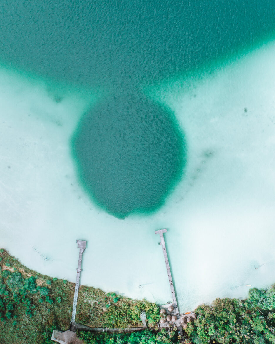 An aerial view of a lake with a hole in it.