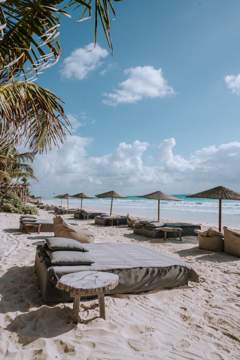 A beach with lounge chairs and umbrellas.