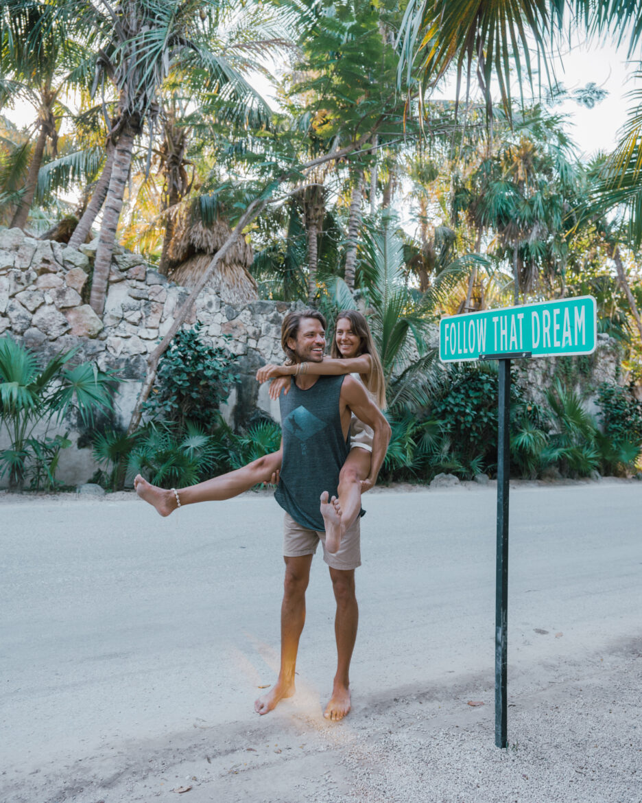 A man and a woman standing in front of a street sign in mexico.