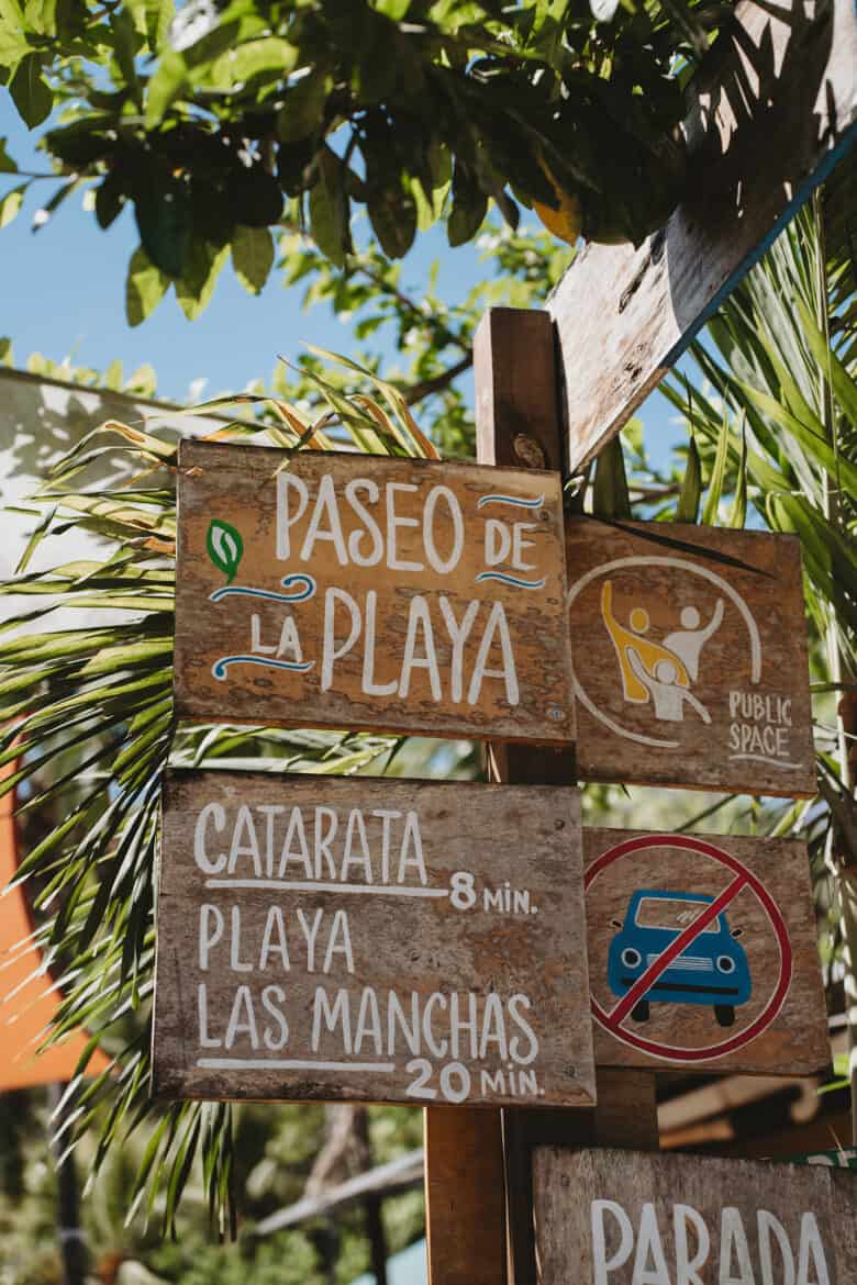 A group of wooden signs on a pole in Montezuma, Costa Rica.