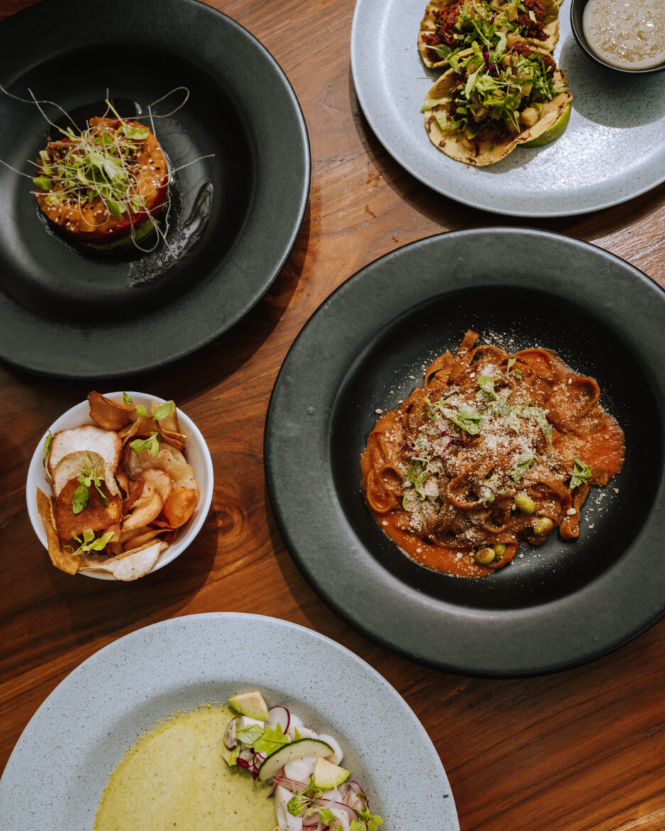 Four plates of food are sitting on a table.